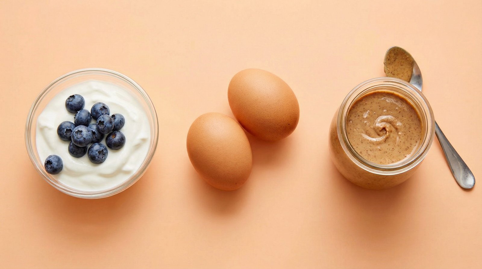 protein-rich breakfast foods for blood sugar — Greek yogurt, eggs, and berries on peach background