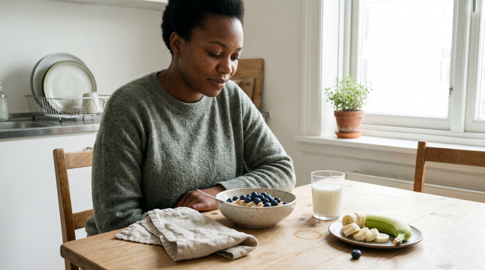 gut health and prediabetes — woman eating oats and kefir at kitchen table for better blood sugar